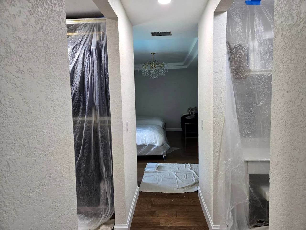 Bedroom furniture, hallway openings and nearby surfaces protected with clear sheeting before service
