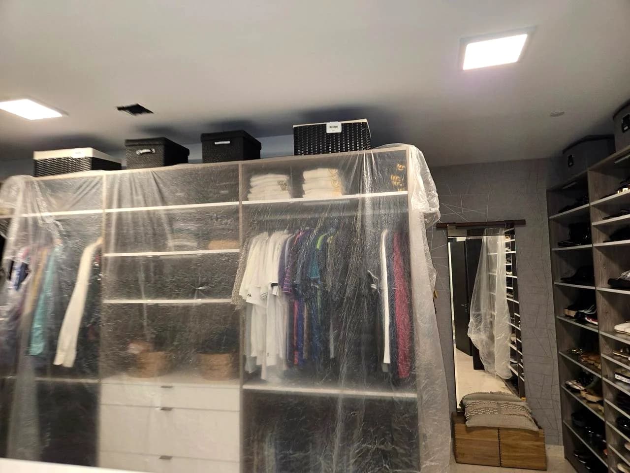 Wardrobe, shelves and clothing protected with clear sheeting before duct service